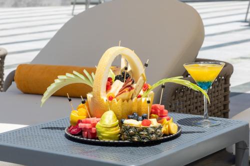 a tray of fruit on a table with a drink at Chamada Girne Hotel Spa and Casino in Kérynia