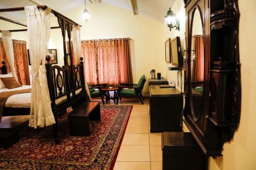 a bedroom with a bed and a living room at The Colonial Manek Manor By SAH in Mount Ābu