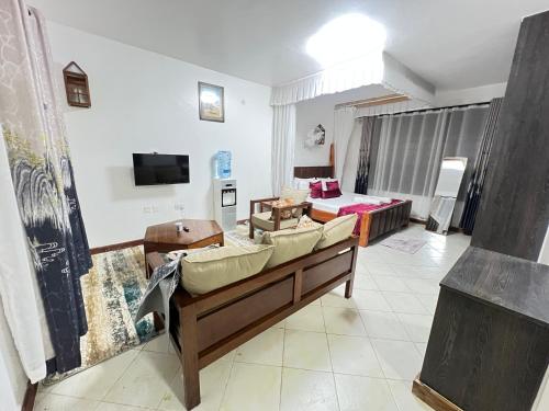 a living room with a couch and a tv at Diani Villa studio in Diani Beach