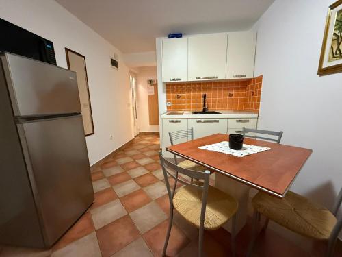 a kitchen with a table and a refrigerator at apartmani selce in Selce