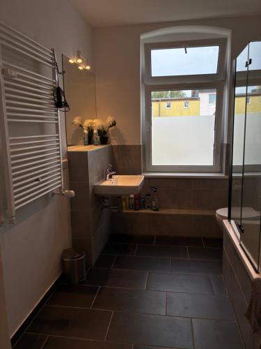 a bathroom with a sink and a window at Neu saniertes Apartment in Magdeburg in Magdeburg