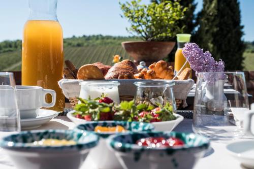 a table with a tray of food and orange juice at Querceto Di Castellina in Castellina in Chianti