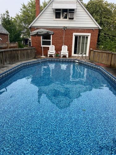 a large blue swimming pool in front of a house at Comfort Home Toronto in Toronto