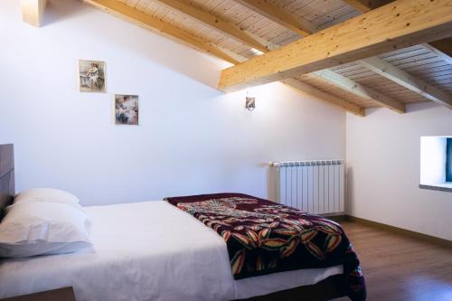 ein Schlafzimmer mit einem Bett in einem Zimmer mit Holzdecken in der Unterkunft Casa da Ladeira in Videmonte