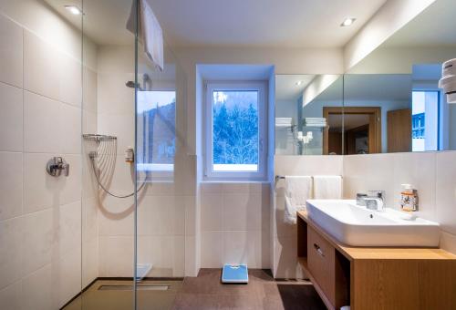 a bathroom with a sink and a shower at Bad Ratzes in Siusi