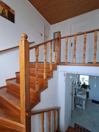 a wooden staircase in a home with white walls at Viola Apartmanház in Bogács