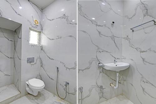 a white bathroom with a toilet and a sink at FabHotel The Ax Inn in Kolkata