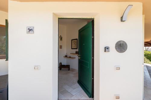 a green door in a room with a tile floor at Villa Pilato in Poggio Dei Pini
