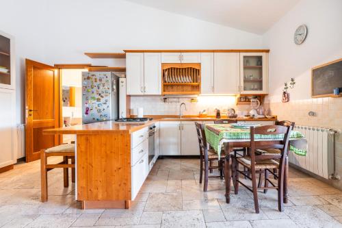 a kitchen with white cabinets and a table and chairs at Villa Pilato in Poggio Dei Pini