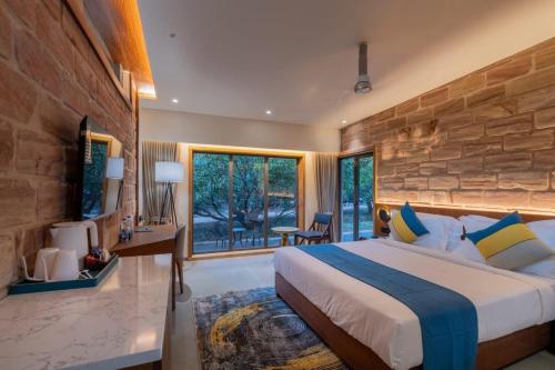 a bedroom with a large bed and a stone wall at Mahavan Resort in Chitrod