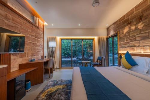 a bedroom with a large bed and a stone wall at Mahavan Resort in Chitrod
