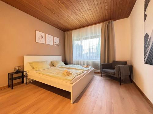 a bedroom with a bed and a chair and a window at 150qm-6 Rooms-Free Privat Parking-2 Bathrooms-Wifi-Yihapartment in Hannover