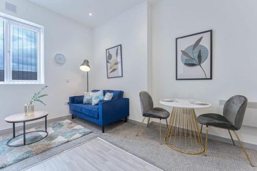 a living room with a blue couch and two chairs at Modern & Cosy Budget 1 Bedroom Flat in Dudley in Dudley