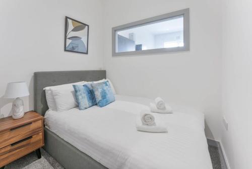 a bedroom with a white bed with a window at Modern & Cosy Budget 1 Bedroom Flat in Dudley in Dudley