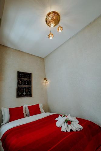 a bedroom with a bed with red and white sheets at Dar Inara in Marrakech