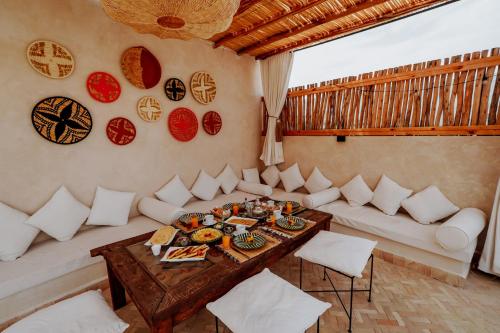a living room with a table and white couches at Dar Inara in Marrakech