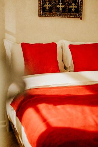 a red and white bed with red sheets and pillows at Dar Inara in Marrakech