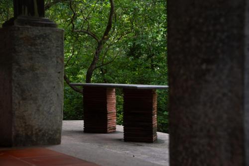 a bench in a park with trees in the background at Seethavanam Farmstay at Forest Edge in Kollengode