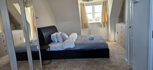 een slaapkamer met een bed met een spiegel en een raam bij Spacious Luxurious Serviced Accommodation 7 in Preston