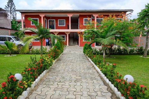 a walkway in front of a house with flowers at Chambre simple Residence Baho Makepe BM in Douala