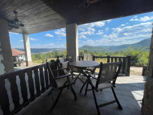a table and chairs on a porch with a view at GeshaHillPark villas 32 in Gesha