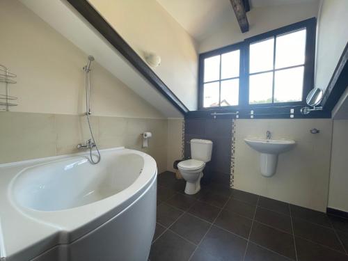 a bathroom with a tub and a toilet and a sink at GeshaHillPark villas 32 in Gesha