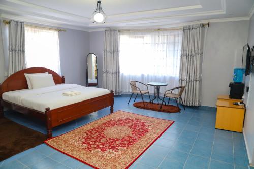 Un dormitorio con una cama y una mesa y sillas. en Guyana Guest House, en Naivasha