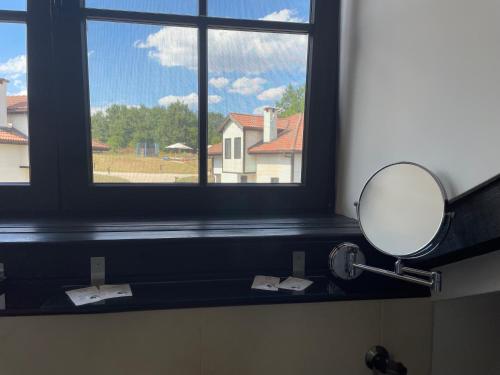 a mirror on a counter in a bathroom with a window at GeshaHillPark villas 32 in Gesha