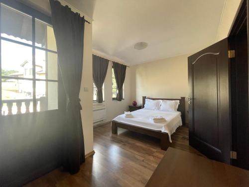 a bedroom with a bed and a large window at GeshaHillPark villas 32 in Gesha
