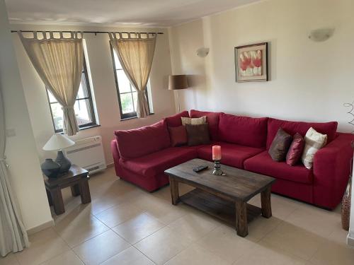 a living room with a red couch and a table at GeshaHillPark villas 32 in Gesha