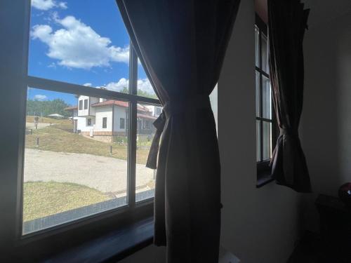a window with a view of a house at GeshaHillPark villas 32 in Gesha