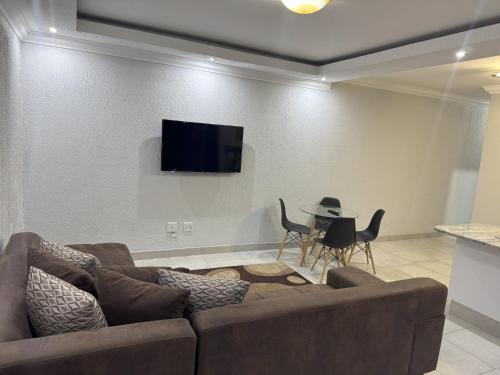 a living room with a couch and a table with chairs at Mikan AirBnB in Otjiwarongo