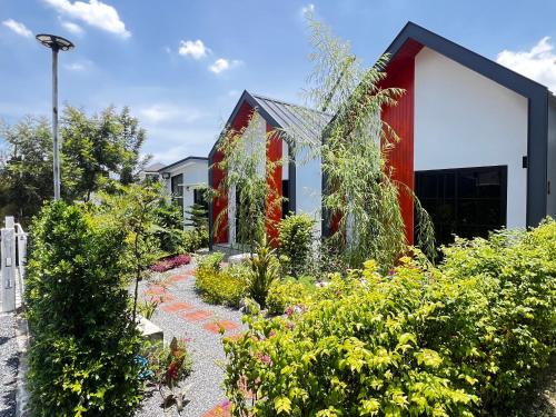 a garden in front of a building with plants at บ้านต้นลมสุวรรณภูมิ Baantonlom suvarnabhumi in Ban Khlong Thewa