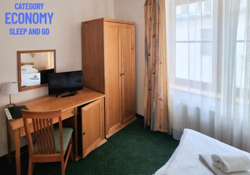 a room with a desk with a computer and a mirror at Hotel Claris in Prague