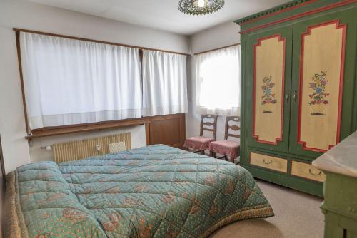 ein Schlafzimmer mit einem Bett und einem grünen Schrank in der Unterkunft Chesa San Gian first floor - Celerina in Celerina