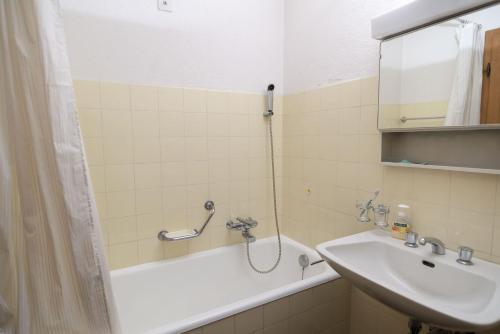 ein Badezimmer mit Badewanne, Waschbecken und Dusche in der Unterkunft Chesa San Gian first floor - Celerina in Celerina