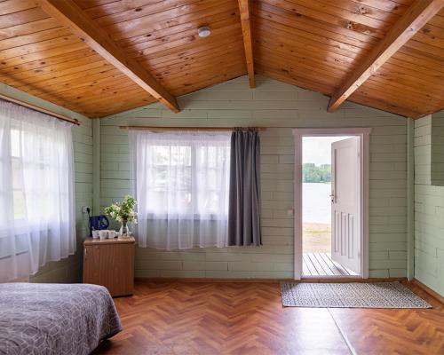 a bedroom with a bed and an open door at Slėnis Trakuose in Trakai