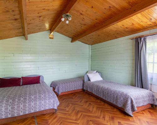 two beds in a room with a wooden ceiling at Slėnis Trakuose in Trakai