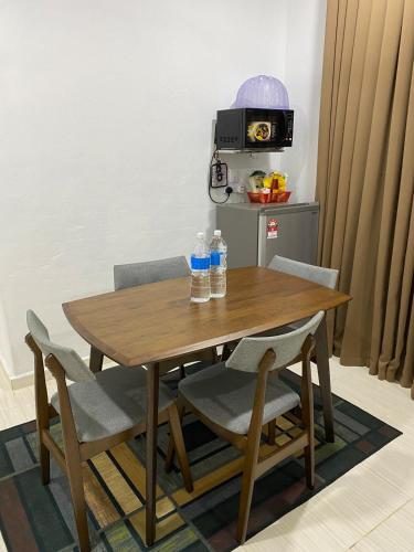 a wooden table with chairs and water bottles on it at Wot Homestay Pool & Soopa Dopa BBQ Cheapest Kelantan in Kampong Pengkalan Dopah