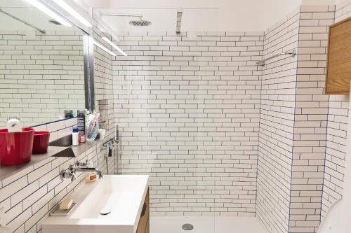 a bathroom with a white tiled shower and a sink at Chesa San Gian ground floor - Celerina in Celerina