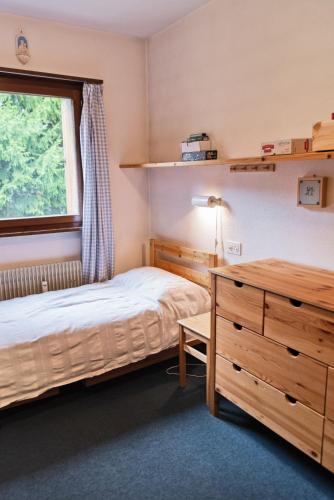 a bedroom with a bed and a desk and a window at Chesa San Gian ground floor - Celerina in Celerina