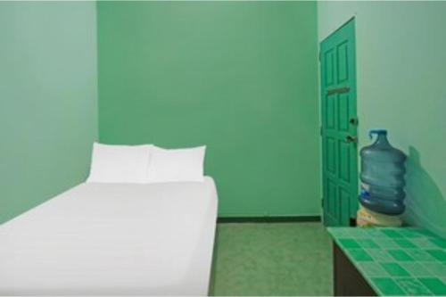 a blue bedroom with a bed and a blue door at Hotel O Homestay Bude Sri in Batam Center