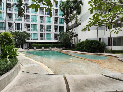 a swimming pool in front of a large building at 5 Floor - The Base Downtown Condominium next to Central Shopping Mall in Phuket