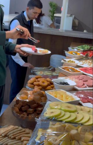 タシュケントにあるHOTEL GLOBUSのビュッフェで皿を持っている人