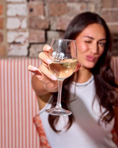a woman holding a glass of white wine at The Lucky Hotel in Newcastle