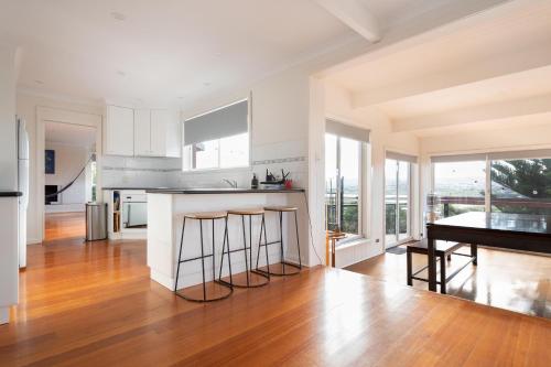 a kitchen with a counter and a table and some windows at The Yard - Comfortable Home in Riverside in Inveresk
