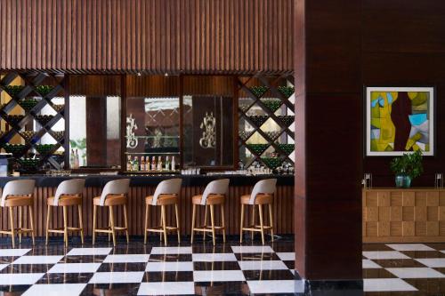 a bar with a row of stools in a restaurant at JAZ Elite Crystal, Almaza Bay in Marsa Matruh