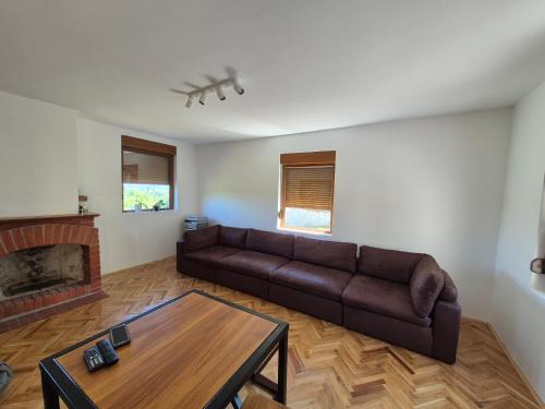 a living room with a couch and a coffee table at Domacinstvo Pecina Petnica in Petnica