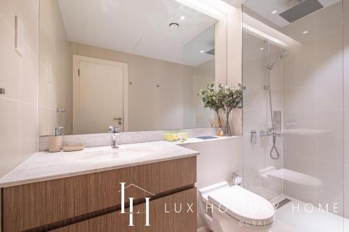 a bathroom with a sink and a toilet and a shower at LUX - The La Mer Sea View Suite 3 in Dubai