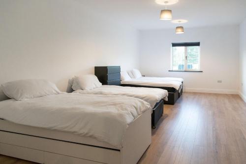 two beds in a room with white walls and wooden floors at Willow Valley in Monaghan